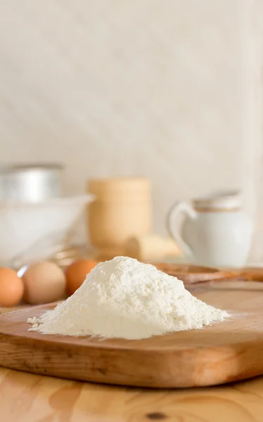 Farina di grano bianco e uova crude per fare pasta e utensili da cucina contro una parete bianca. Concetto di cucina rustica, attenzione selettiva. Ricevuto. Spazio libero per il testo — Foto Stock