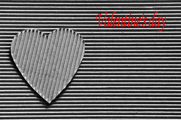 Valentine - heart symbol carved out of corrugated cardboard. Copy space. Free space for text, Close-up, top view. Black and white photo with the inscription red color — Stock Photo, Image