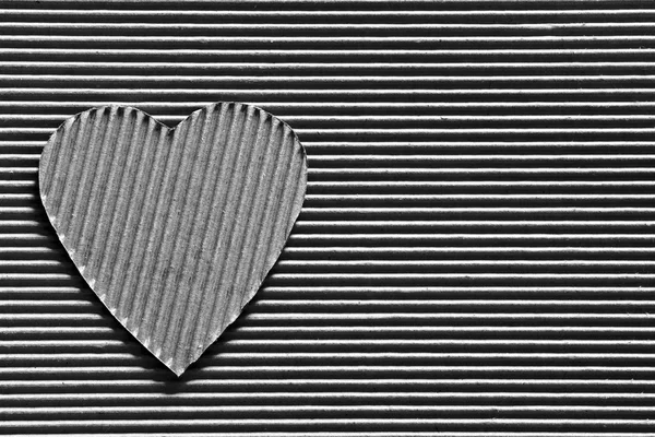 Valentine - heart symbol carved out of corrugated cardboard. Copy space. Free space for text, Close-up, top view. Black and white photo — Stock Photo, Image