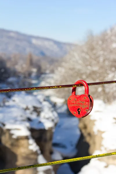 Vieux cadenas rouge fermé en forme de coeur sur un fond de canyon hivernal de montagne — Photo