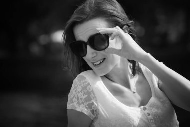 Büyük güneş gözlüklü beyaz bir kadının siyah beyaz portresi.