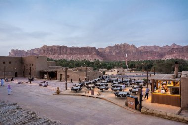 Al Ula, Suudi Arabistan - 22 Nisan 2025: Gün batımında arka planda dağlarla birlikte bir Al Ula restoranı manzarası