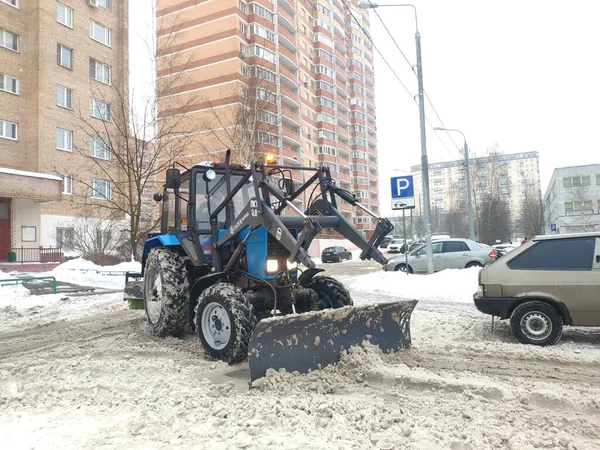 Moscú, Rusia - 23 de enero de 2021: tractor limpia la nieve en la ciudad. tractor quitanieves despeja camino nevado después de ventisca — Foto de Stock