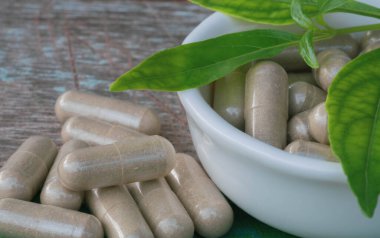 Andrographis 'in tahta arka planda paniklediği kapsüller, Andrographis' in paniklediği bitki virüs hücrelerinin bölünmesini engelliyor..