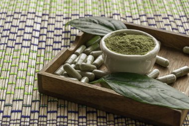 Beyaz bir fincanda paniğe kapılan toz (Kariya) ve güzel bir arka planda uçan dairenin içindeki bitkisel kapsüllerle ayrılır..