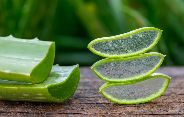 Färsk Aloe Vera Skivor Träbord Och Naturlig Grön Bakgrund — Stockfoto