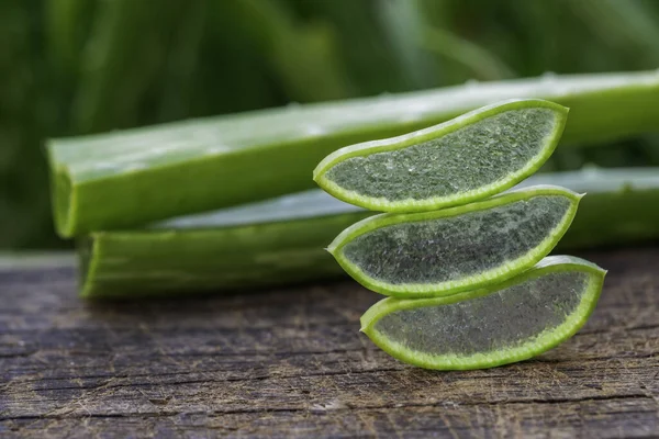 Färsk Aloe Vera Skivor Träbord Och Naturlig Grön Bakgrund — Stockfoto