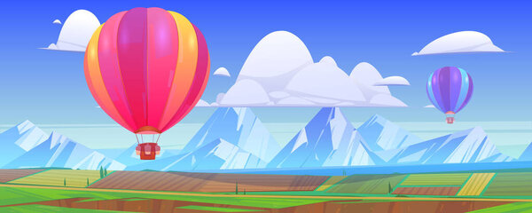 Hot air balloons fly above mountain landscape