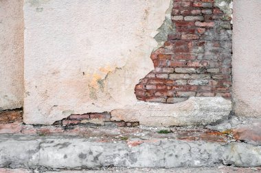 Eski gül alçılı tuğla duvar ve eski asfalt.