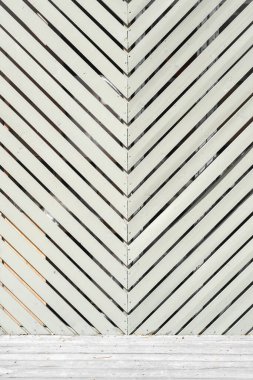 Arkaplan resmi. Duvar boyalı gri-yeşil ahşap bir katman ve havada gri-gümüşe dönen boyanmamış tahta kaldırım ile tamamlandı..