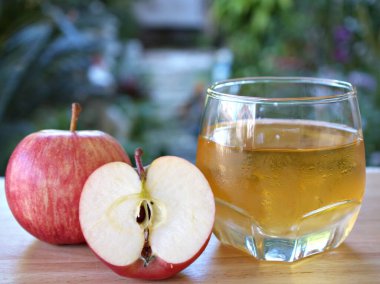 Bahçede elma suyu ve kırmızı elma meyvesi