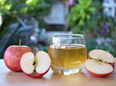 Bahçede elma suyu ve kırmızı elma meyvesi