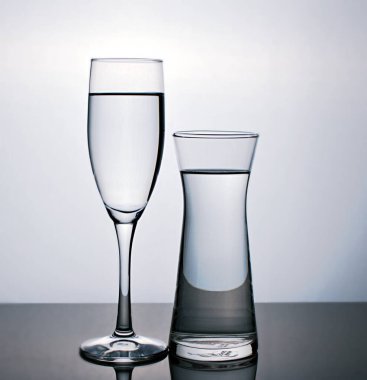 Arka plan için siyah beyaz görüntüde izole edilmiş bir bardak su, bir bardak şarap, yemek takımı.