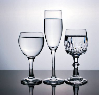 Arka plan için siyah beyaz görüntüde izole edilmiş bir bardak su, bir bardak şarap, yemek takımı.