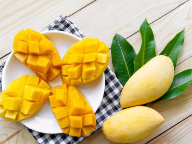 Ahşap kaplama beyaz tabakta mango sarısı. meyve yiyecekleri tropikal Tayland konsepti.