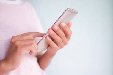 Akıllı telefonu evde çalışmak için kullanan ve arkadaşlarıyla sohbet eden, internetten alışveriş yapan bir kadın. İş ve teknoloji kavramı.