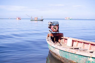 Eski tekne, bulanık mavi deniz ve mavi gökyüzüne kıyıya vuran balıkçı teknesi. Denizci Tayland 'ın yaşam tarzı. otantik doğa.