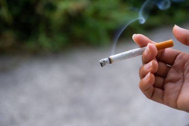 Arka planda sigara içmek için parmak tutmak. Tehlikeli bir ilaç. Bağımlı madde. narkotik kavram.