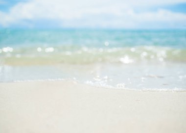 Kum kumsalı ve mavi deniz ve mavi gökyüzü olan yumuşak dalgalar. Doğa okyanusu. Tatillerde turist tatili.