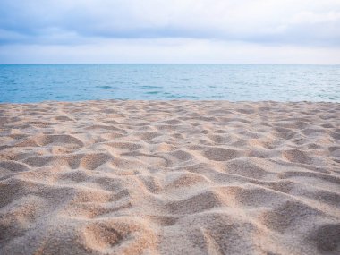 Sahildeki kumsal ve bulanık mavi deniz ve mavi gökyüzü. Turist seyahati tropik yaz tatili doğa kavramı.