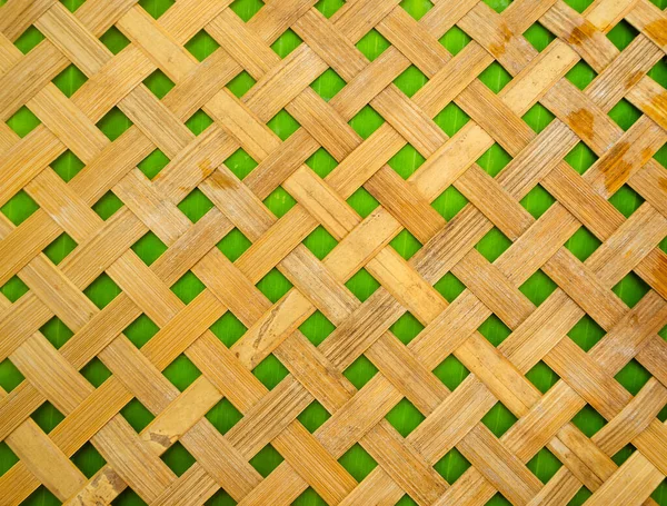 Wooden bamboo design wicker yellow on green banana background. for presentation organic food or drink. abstract pattern nature hand made concept.