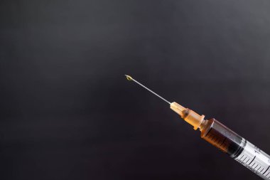 Siyah arka planda şırıngada eroin. Uyuşturucu, afyon, bağımlılık yapıcı madde, alışkanlık yapıcı madde, uyuşturucu konsepti.