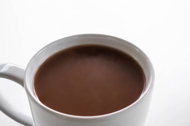 Çikolatalı süt beyaz arka planda beyaz bardakta kapanıyor. Sabahları sıcak hindistan cevizi, sağlık için. Dünya Çikolata Günü ve aperatif veya kahvaltı konsepti.