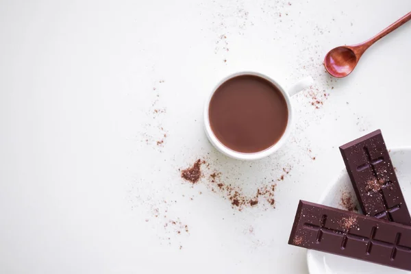 Chocolate milk in white cup with bar chocolate in whit plate on white background. coco hot drink in the morning for health. World Chocolate Day and snack or breakfast concept. flat lay copy space.