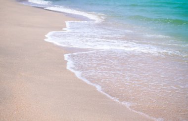 OLYMPUS DIGITAL CAMERASoft sahildeki kumsalda mavi denizi dalgalandırıyor. Doğal tatil için yaz tatili konsepti.