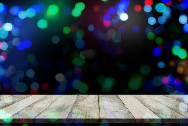 Renkli bokeh arkaplan mutlu yeni yıl 2022 montaj ahşap masa perspektifi odak çemberi duvar kağıdından soyut efekt gece görüntüsü. Noel partisi için bayram arkaplanı.