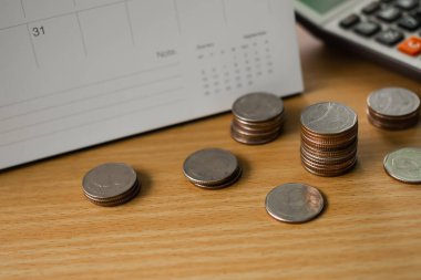 Tahta zemin üzerinde hesap makinesi ve takvim bulunan Tayland paralarını istifleyin. planlama yatırım kazanır ve 2022 yeni yılı için para biriktirir. finans ve iş kavramı.