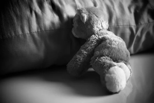 只有泰迪熊一个人坐在黑色和白色的枕头旁边 忧郁的遗憾 失望的哭泣孤独的悲伤符号 被遗弃儿童或伤心儿童海报卡概念 — 图库照片
