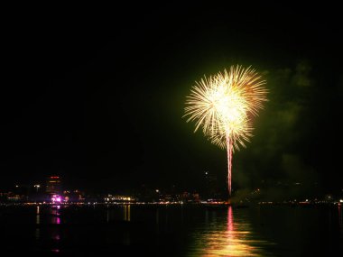 Havai fişekler gökyüzünde güzel sarı ışık karanlık bir gecede, karanlık okyanus festivali pattaya thailand 'ın gölgesinde. Yıldönümünü kutlamak ya da 2022 yılının mutlu noelleri için boş alan.