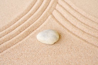 Zen bahçe taşı Japon tırmık kumu üzerinde. Sahildeki taş ya da çakıl taşları zihin rahatlığı ve meditasyon için açık havada tasarlanır. Chan Budizm din kavramı.