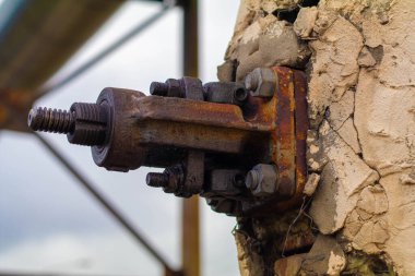 Beton duvarda paslı bir cıvata parçalanıyor.