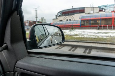 Araba aynasında yansıma, ıslak havada yağmur damlaları.