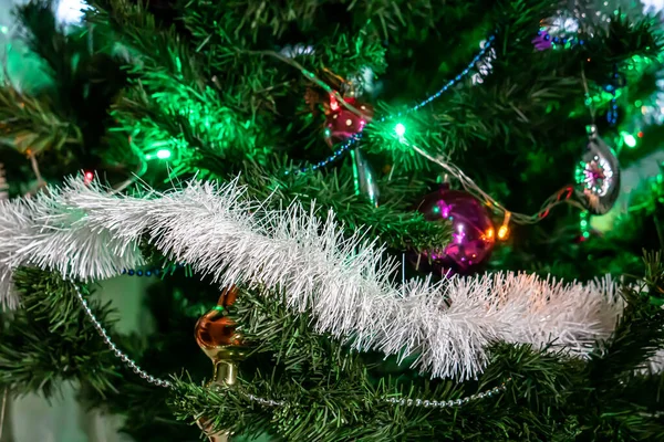 Weihnachtsfichte mit Girlanden, Lichtern und Spielzeug dekoriert — Stockfoto