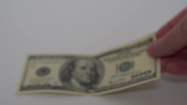 Uma mão põe para fora uma nota velha e nova de 100 dólares na mesa — Vídeo de Stock
