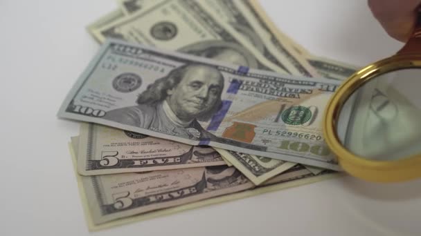 Orijinallik için Amerikan dolarlarını büyüteçle kontrol ediyorum. — Stok video