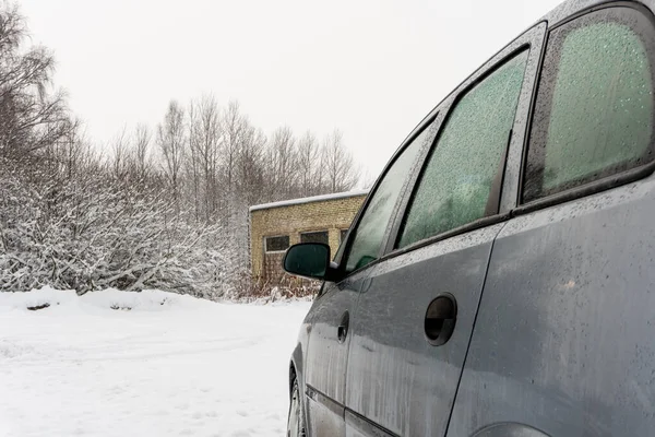 Dirty car on the background of an abandoned building and bushes on a snowy road, car breakdown on the road — Stock Photo, Image