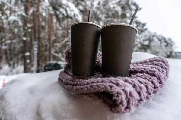Dos tazas de papel con café mantener caliente en una bufanda en la nieve, cuento de amor de invierno —  Fotos de Stock