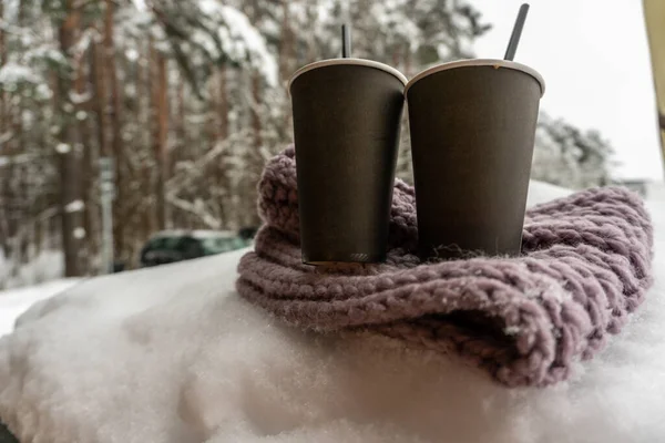 Δύο χάρτινα φλιτζάνια με καφέ ζεσταίνονται σε ένα μαντήλι στο χιόνι, χειμωνιάτικη ιστορία αγάπης — Φωτογραφία Αρχείου