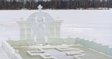 İsa 'nın ve buzdan heykelin vaftiz töreninde bir melek ve haç şeklinde buzdan bir deliğe daldırma yazı tipi.