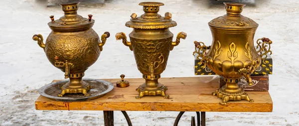 Русский золотой самовар с горячим напитком на столе зимой, роскошный чайник, антиквариат — стоковое фото