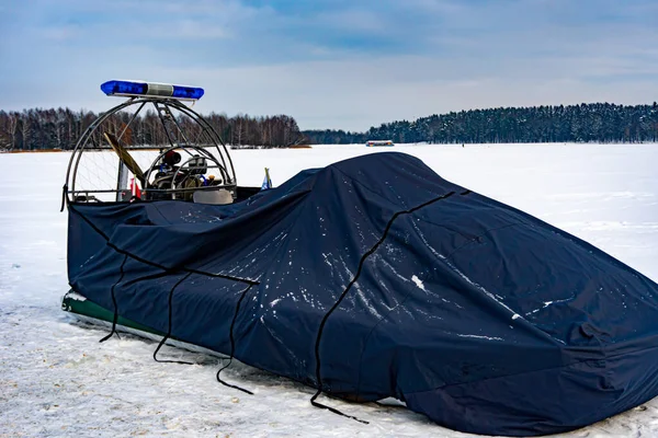 Police hovercraft or air-cushion vehicle or ACV under tent, police flashers on a snowmobile close up, police all-terrain vehicle in winter, air-cushion boat