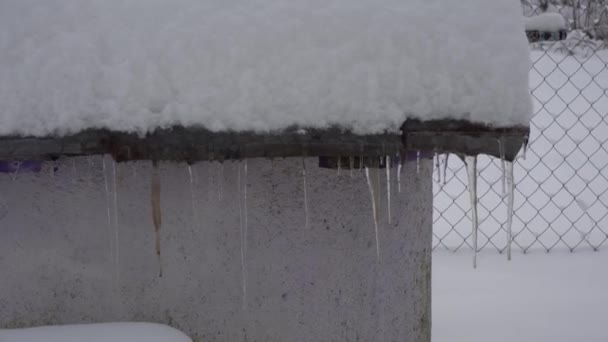 El hombre derriba carámbanos con una pala, carámbanos de invierno en el techo — Vídeos de Stock