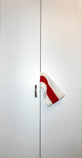 캐비닛 문 밖으로 흰 스카프를 두르고 있는 흰 흰색 막대 — 스톡 사진