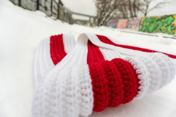 Bufanda de punto blanco-rojo-blanco en la nieve en la calle — Foto de Stock