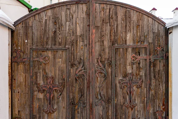 Grande porta de madeira marrom antigo maciço com ganchos e cortinas, textura de madeira — Fotografia de Stock