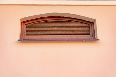 Pembe duvardaki antika havalandırma penceresi, paslı pencere deseni.